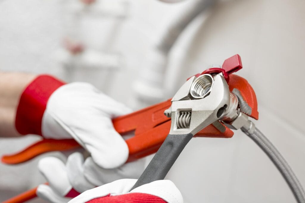 Plumber holding pipe wrenches for an emergency repair in Clermont
