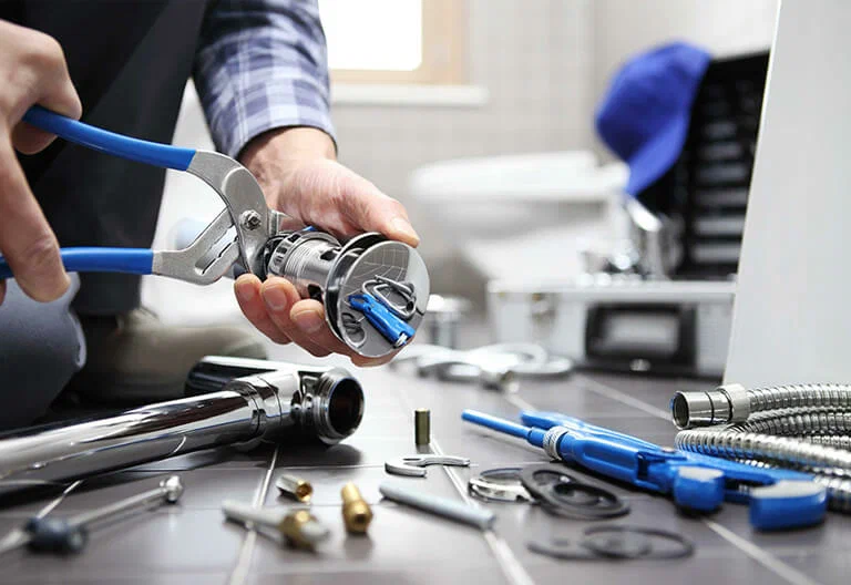 Technician repairing a plumbing fixture with professional tools in Clermont